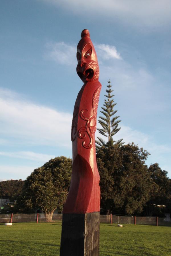 Im Gelände sind Holzschnitzereien der Maori aufgestellt.