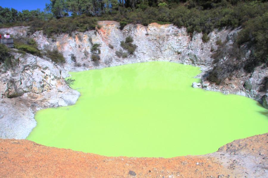 Teufelsbad: Man sieht einen zerklüfteten Krater mit einer erstaunlich natürlichen Wasserfarbe auf dem Grund. Je grüner die Wasserfarbe ist, desto mehr Arsensulfide enthält das Wasser.