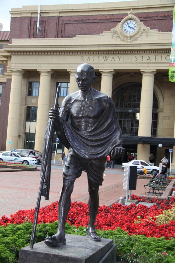 Mahatma Gandhi-Denkmal vor dem Bahnhofsgebäude.