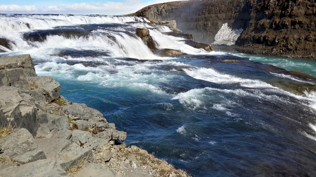 Glasklares Wasser fließt in hoher Geschwindigkeit über die Basaltkanten.